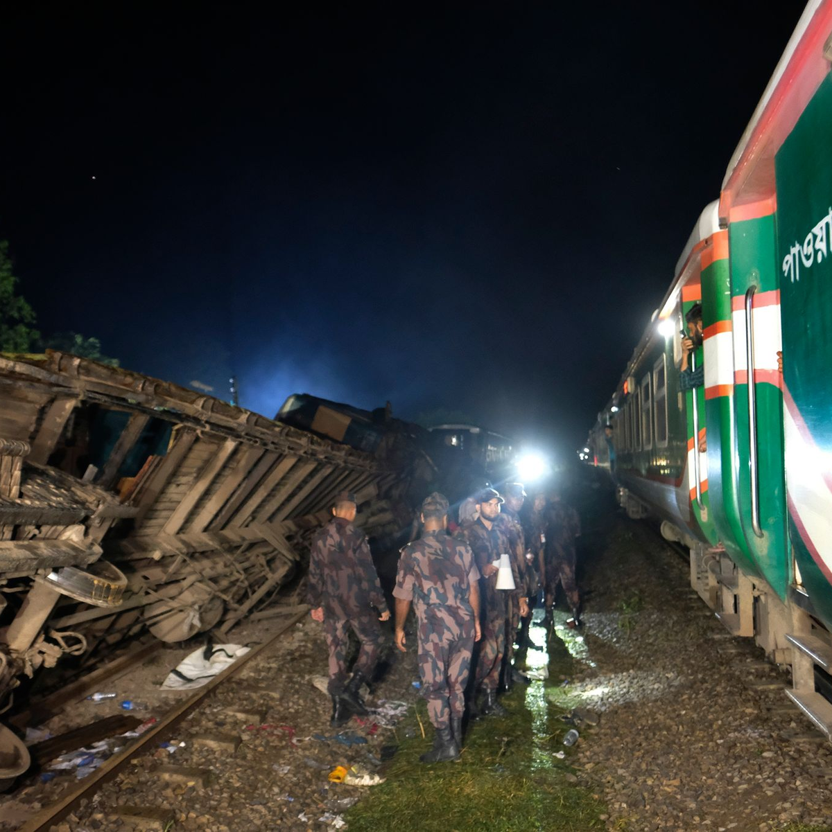 Polizisten stehen an der Unfallstelle Wache. - Foto: Mahmud Hossain Opu/AP/dpa