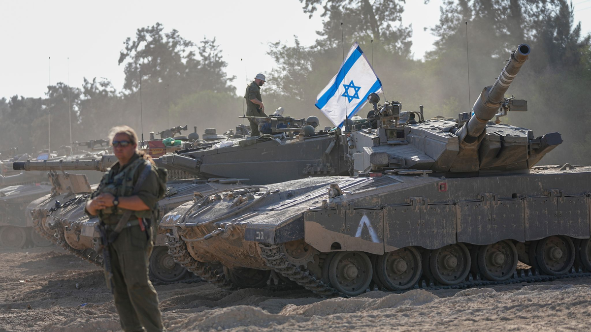 Israelische Soldaten arbeiten an einem Panzer in der Nähe der Grenze zum Gazastreifen. Bislang ist offen, wann das israelische Militär eine Bodenoffensive im Gazastreifen beginnt. - Foto: Ohad Zwigenberg/AP/dpa