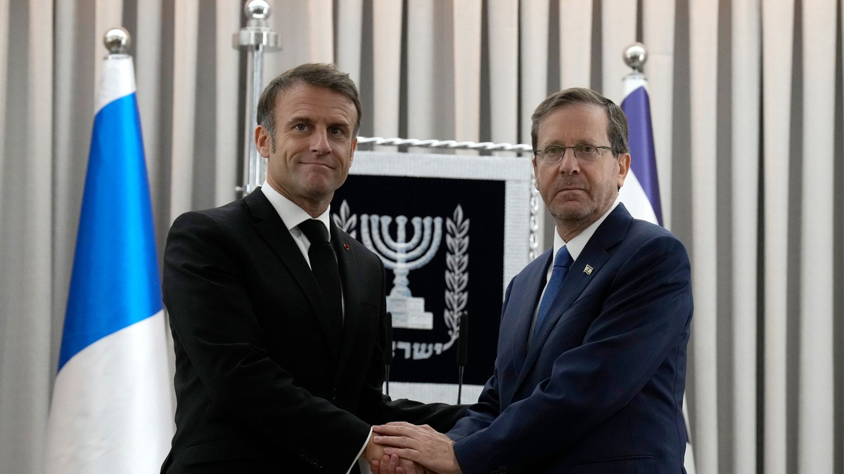 Emmanuel Macron (l), Präsident von Frankreich, schüttelt Izchak Herzog, Präsident von Israel, die Hand. Frankreichs Präsident Macron ist zu einem zweitägigem Besuch in Israel. - Foto: Christophe Ena/AP Pool/dpa