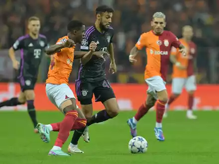 Noussair Mazraoui vom FC Bayern München (M) im Duell mit Wilfried Zaha von Galatasaray Istanbul. - Foto: Peter Kneffel/dpa