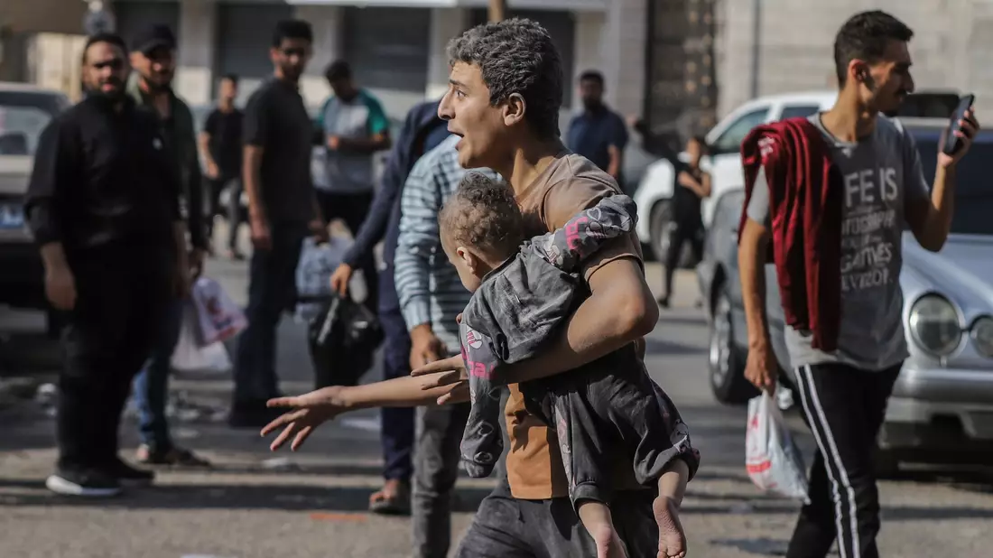 Ein Mann trägt nach einem israelischen Luftangriff auf Gaza-Stadt ein verletztes Kind auf dem Arm. - Bild: Mohammed Abu Elsebah/dpa