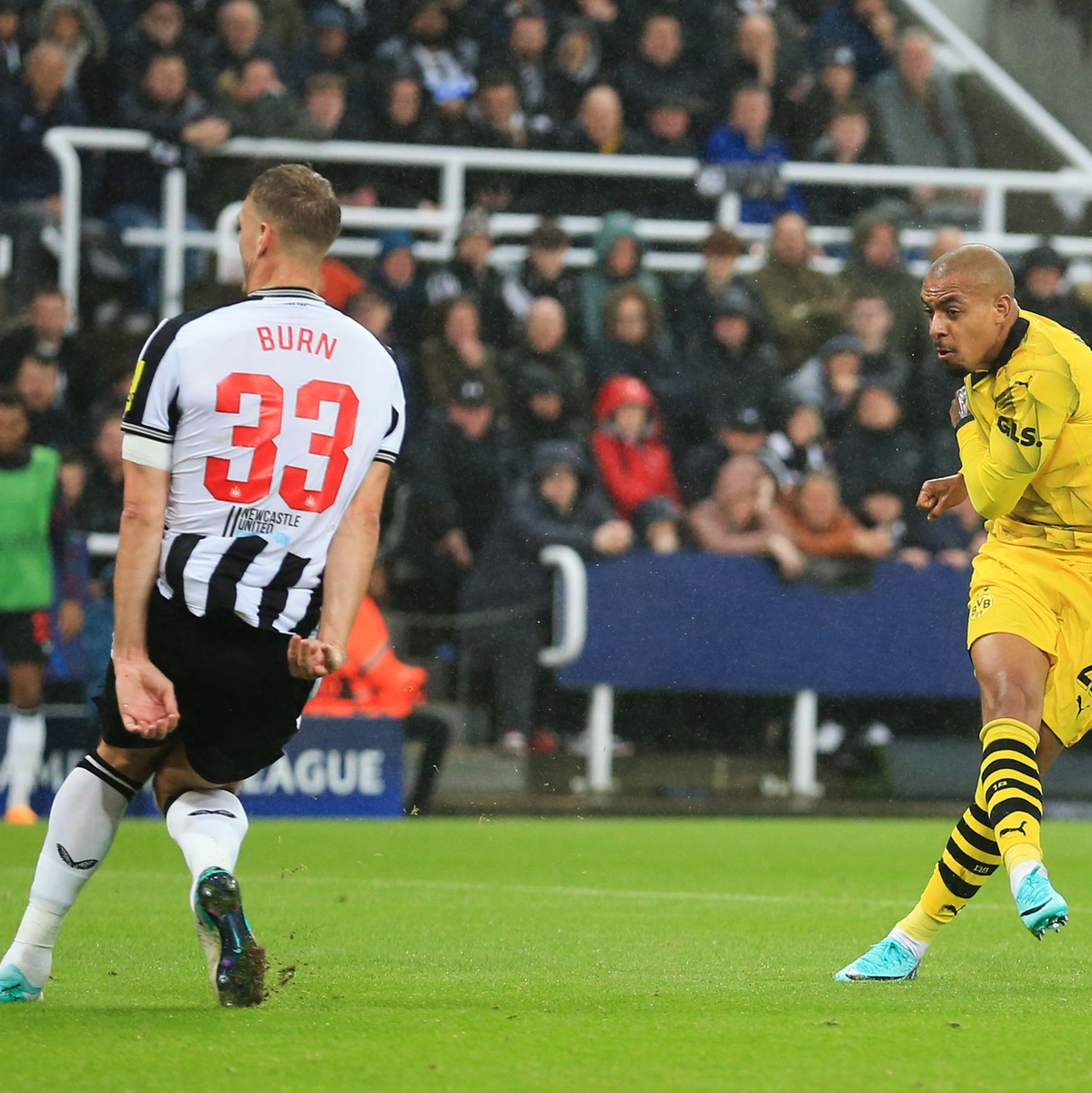 Donyell Malen (r) zieht ab - Newcastles Dan Burn kommt zu spät. - Foto: Lindsey Parnaby/dpa