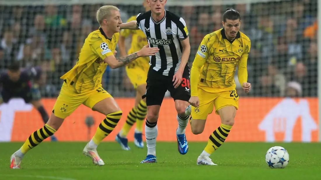 Marco Reus (l) und Marcel Sabitzer (r) doppeln Newcastles Sean Longstaff. - Bild: Lindsey Parnaby/dpa