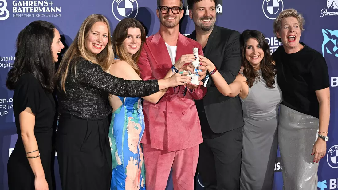 Joko Winterscheidt (M) und sein Team freuen sich über den Preis bei der Verleihung des TV- und Streaming-Awards Blauer Panther. - Bild: Felix Hörhager/dpa