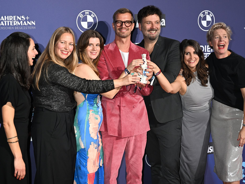 Joko Winterscheidt (M) und sein Team freuen sich über den Preis bei der Verleihung des TV- und Streaming-Awards Blauer Panther. - Foto: Felix Hörhager/dpa