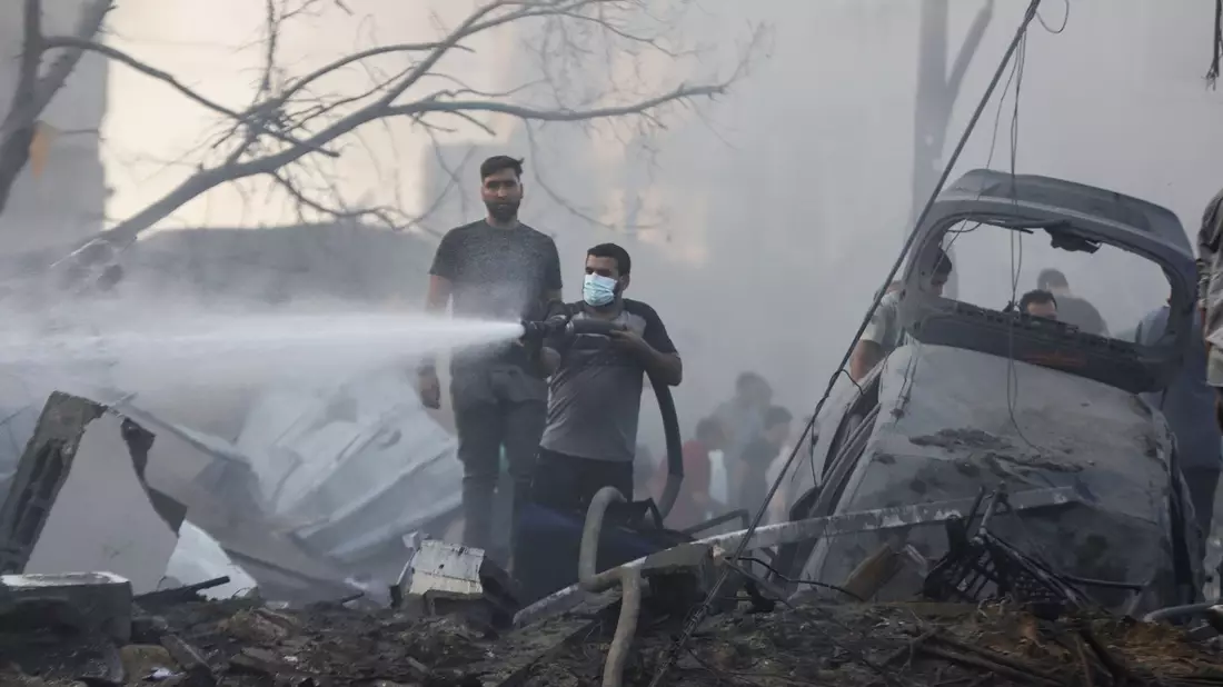 Ein Palästinenser löscht nach einem israelischen Luftangriff Brandherde in den Trümmern eines zerstörten Gebäudes im Gazastreifen. - Bild: Mohammed Abu Elsebah/dpa