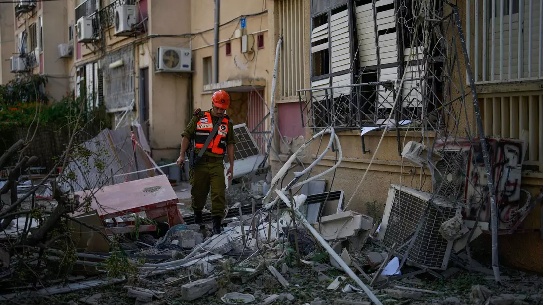 Ein israelischer Soldat inspiziert ein beschädigtes Wohnhaus in Rishon Lezion, nachdem dieses von einer Rakete aus dem Gazastreifen getroffen wurde. - Bild: Francisco Seco/AP