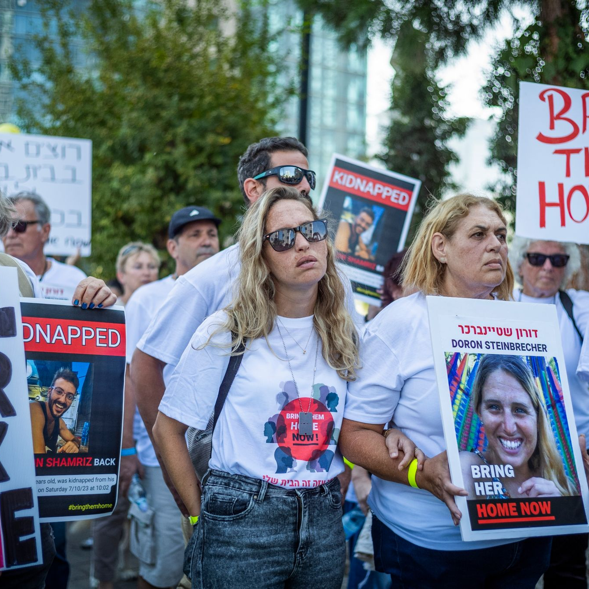 Einwohner von Kfar Azza halten während einer Demonstration Plakate von israelischen Geiseln, die von militanten palästinensischen Hamas-Kämpfern festgehalten werden. - Foto: Ilia Yefimovich/dpa