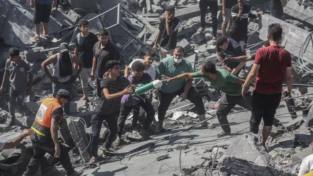 Palästinenser durchsuchen die Trümmer eines Gebäudes in Chan Yunis, das bei einem israelischen Luftangriff zerstört wurde. - Bild: Mohammed Talatene/dpa