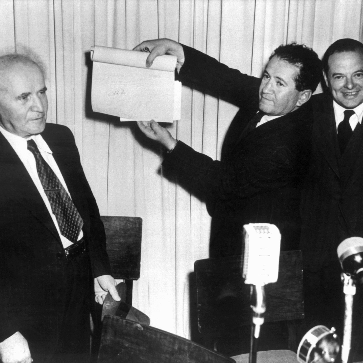 In Anwesenheit von mehreren hundert Personen unterzeichneten Vertreter aller jüdischer Parteien und der Jewish Agency die «Unabhängigkeits-Deklaration» des neuen jüdischen Staates Israel. Eine nicht identifizierte Person hält das Schriftstück hoch. - Foto: dpa