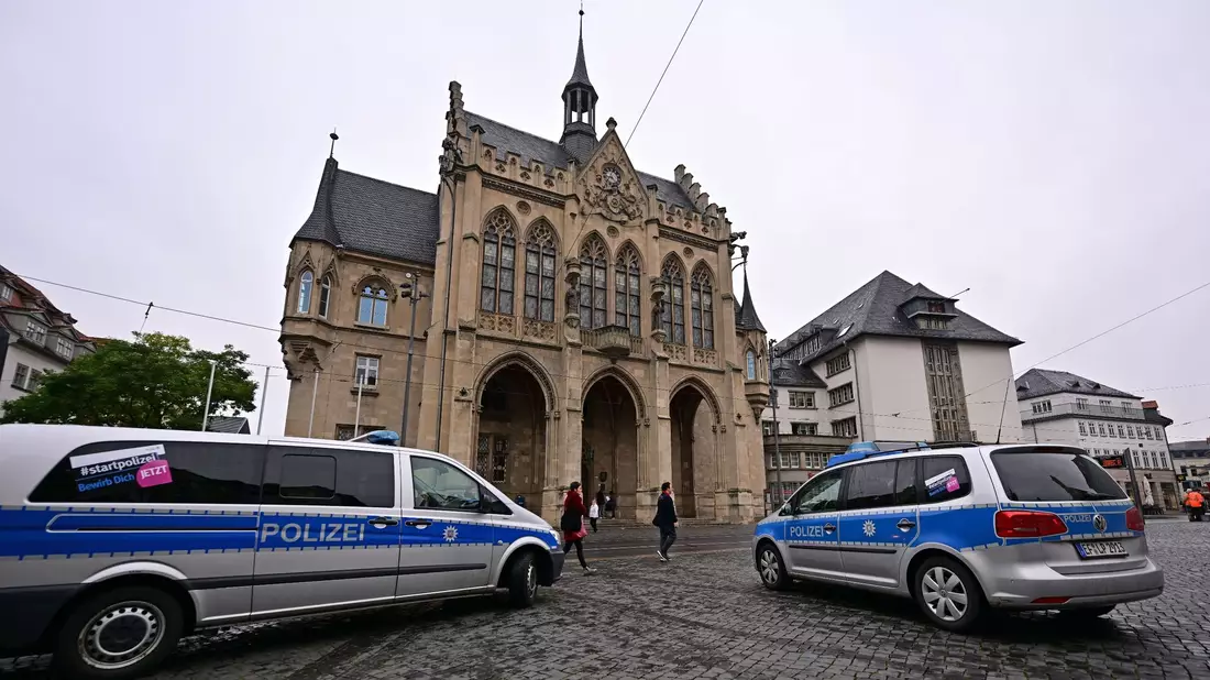 Polizeifahrzeuge stehen nach einer Bombendrohung vor dem Erfurter Rathaus. - Bild: Martin Schutt/dpa