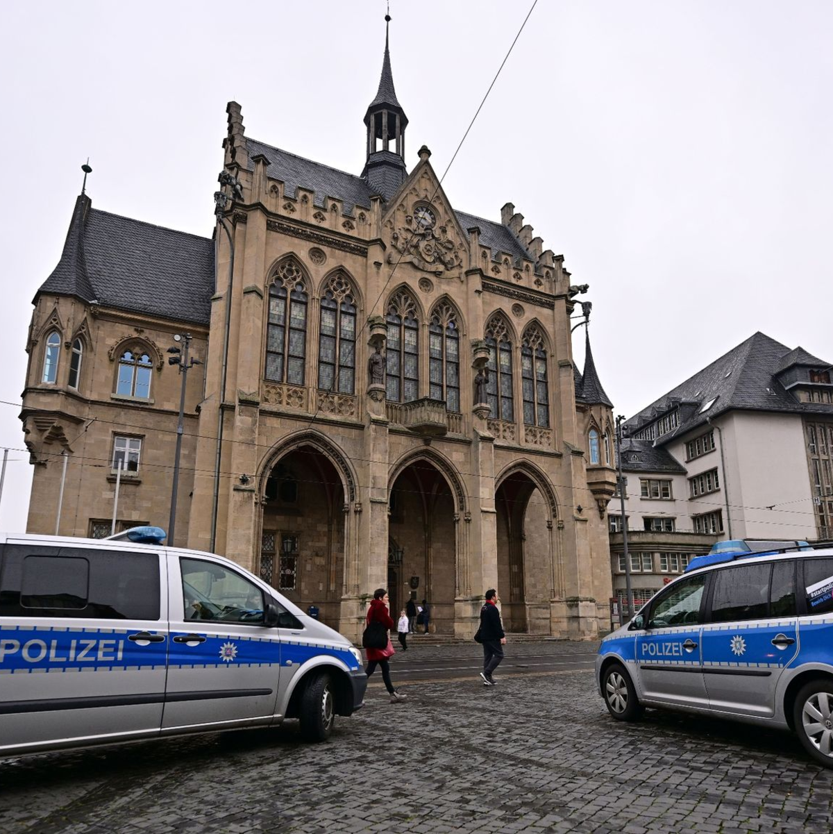 Polizeifahrzeuge stehen nach einer Bombendrohung vor dem Erfurter Rathaus. - Foto: Martin Schutt/dpa