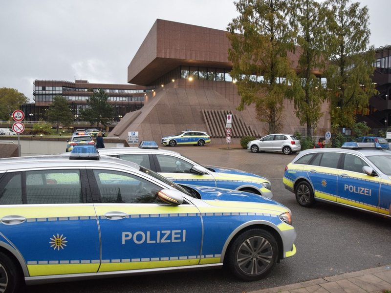 Einsatzkräfte der Polizei stehen vor der Universität in Mannheim. Das Landeskriminalamt ermittelt nun zu dem tödlichen Polizeieinsatz. - Foto: Rene Priebe/dpa