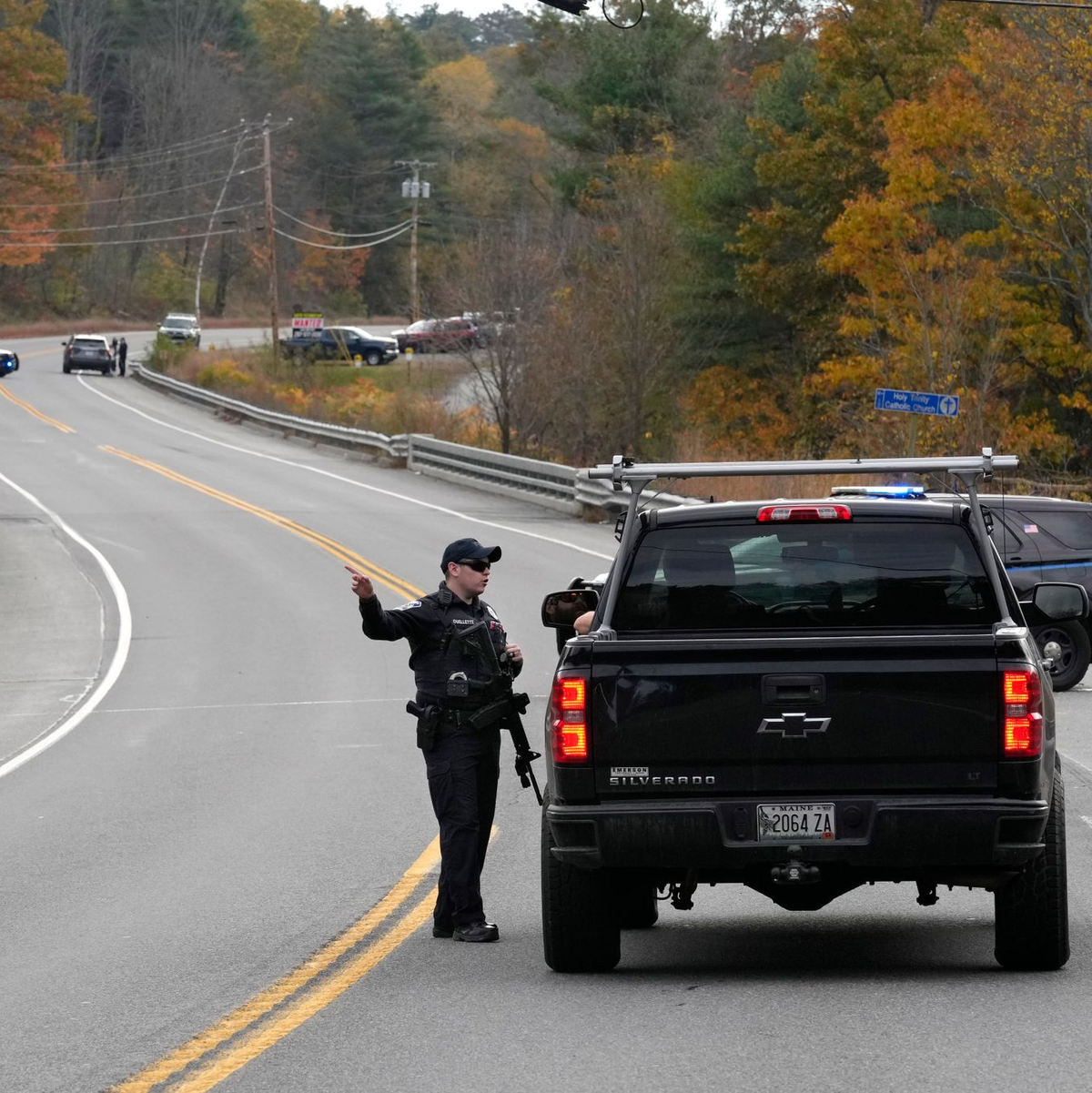 Polizeibeamte sprechen bei einer Straßensperre während der Fahndung nach einem Schusswaffenangriff mit einem Autofahrer. - Foto: Robert F. Bukaty/AP/dpa
