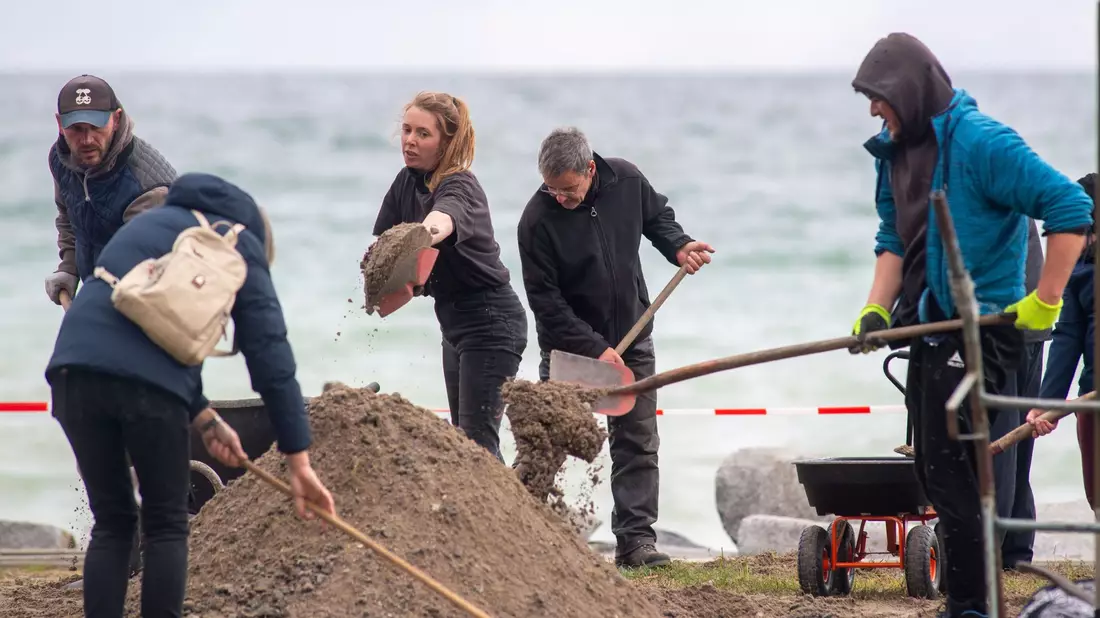 Hunderte Freiwillige beseitigen auf Rügen an der Promenade in Sassnitz die Hinterlassenschaften der schweren Ostsee-Sturmflut. - Bild: Stefan Sauer/dpa