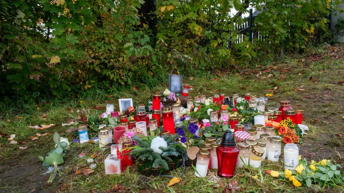Blumen und Kerzen im Gedenken an einen Obdachlosen. Er wurde mit Messerstichen getötet. - Bild: Sebastian Vogt/Stadt Horn-Bad Meinberg/dpa