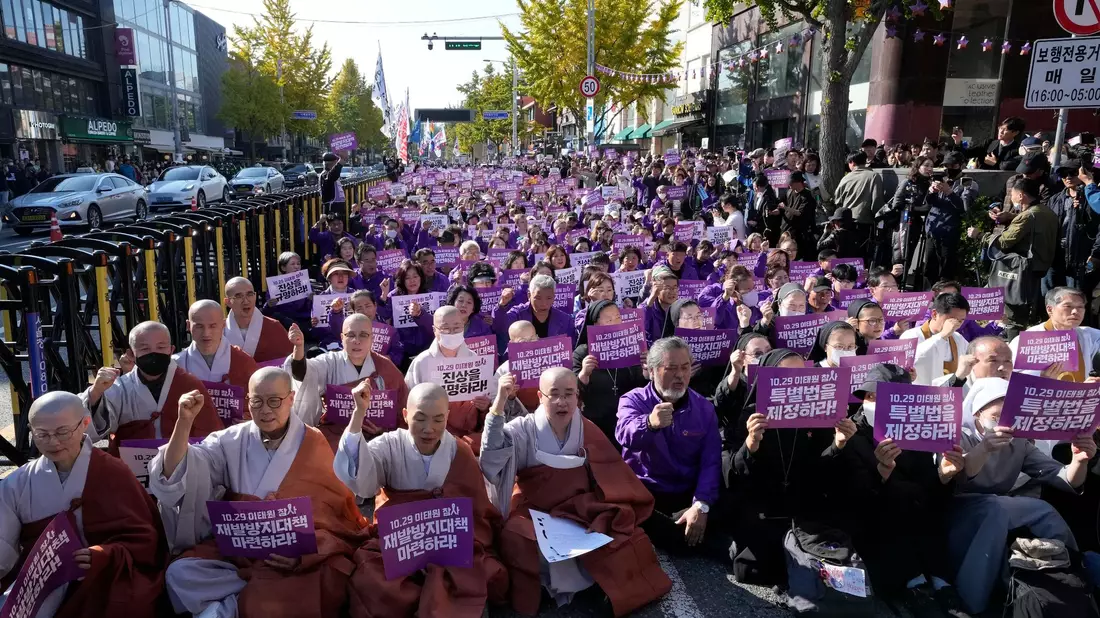 Menschen skandieren während eines Gottesdienstes in Seoul anlässlich des ersten Jahrestages der tödlichen Massenpanik mit vielen Todesopfern. - Bild: Ahn Young-joon/AP