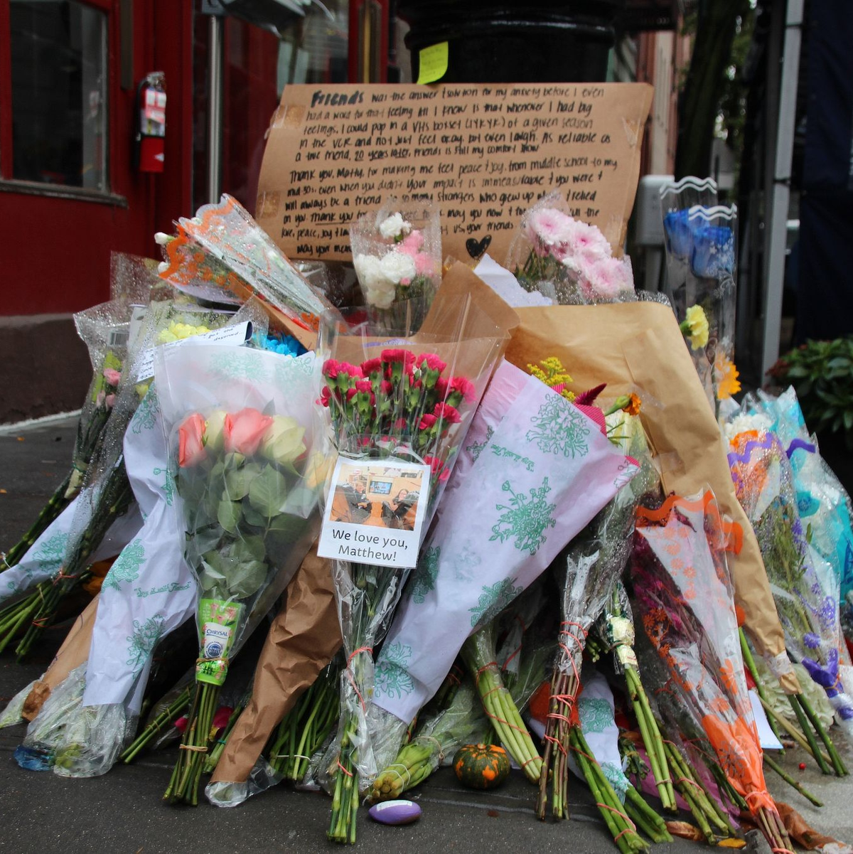 Blumen und Botschaften im Gedenken an  Matthew Perry vor dem «Friends»-Haus in New York. - Foto: Christina Horsten/dpa