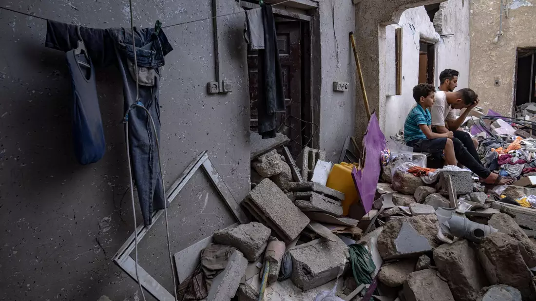 Nachdem es von einem israelischen Luftangriff getroffen wurde, sitzen Palästinenser auf den Trümmern eines Hauses Chan Junis. - Bild: Fatima Shbair/AP