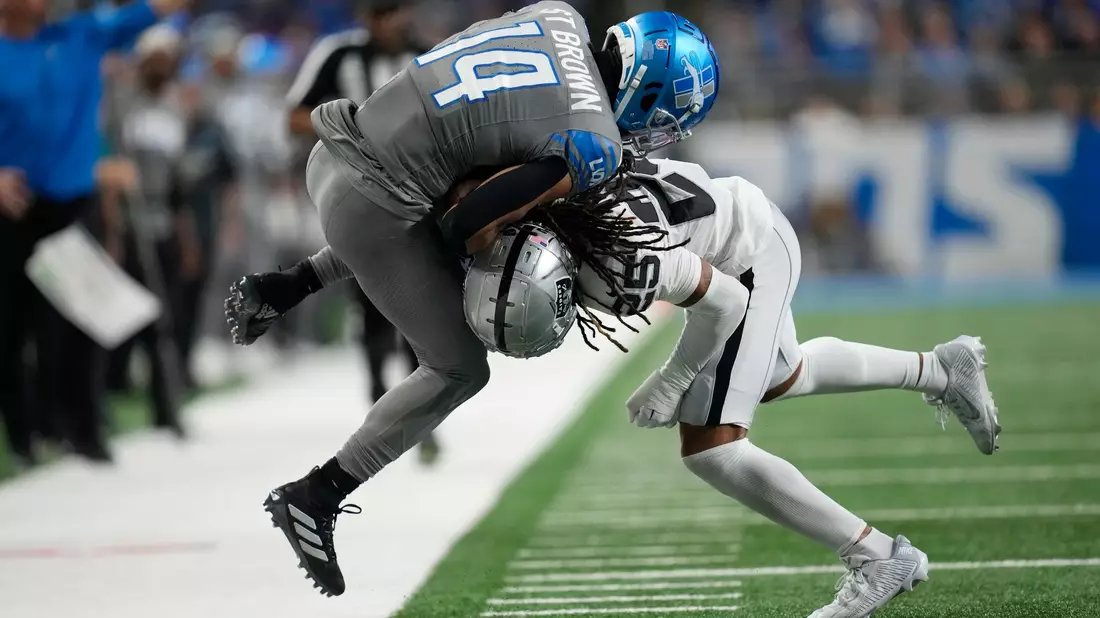 Detroit Lions Wide Receiver Amon-Ra St. Brown (14) wird von Las Vegas Raiders Safety Tre'von Moehrig (25) aus dem Spielfeld gedrängt. - Bild: Paul Sancya/AP