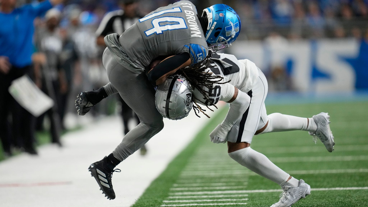 Detroit Lions Wide Receiver Amon-Ra St. Brown (14) wird von Las Vegas Raiders Safety Tre'von Moehrig (25) aus dem Spielfeld gedrängt. - Foto: Paul Sancya/AP