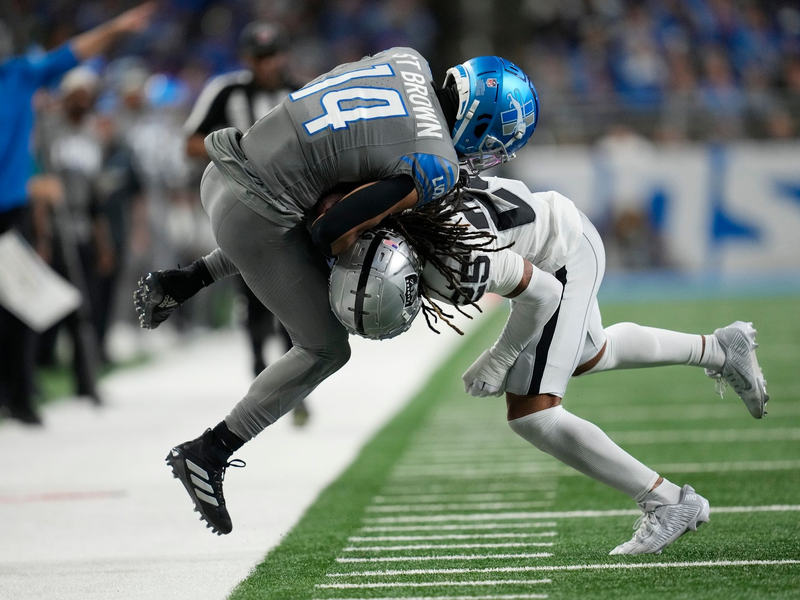 Detroit Lions Wide Receiver Amon-Ra St. Brown (14) wird von Las Vegas Raiders Safety Tre'von Moehrig (25) aus dem Spielfeld gedrängt. - Foto: Paul Sancya/AP
