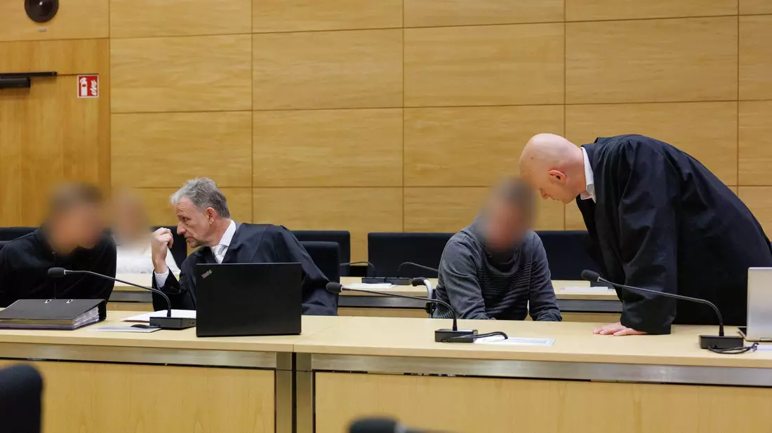 Christian Thüner (2.v.l) und Jerrit Schöll (r), die Verteidiger der Angeklagten, sprechen mit ihren Mandanten in einem Saal des Landgericht Bielefeld zum Auftakt im Prozess um ein illegales Motorradrennen mit Todesfolge. - Bild: Friso Gentsch/dpa