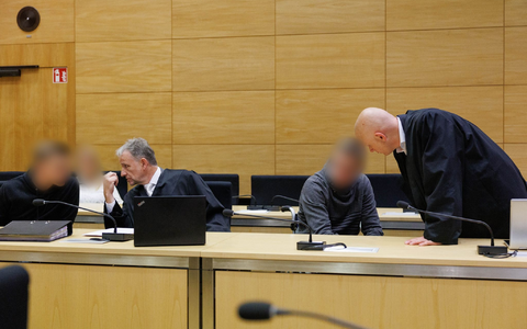Christian Thüner (2.v.l) und Jerrit Schöll (r), die Verteidiger der Angeklagten, sprechen mit ihren Mandanten in einem Saal des Landgericht Bielefeld zum Auftakt im Prozess um ein illegales Motorradrennen mit Todesfolge. - Foto: Friso Gentsch/dpa