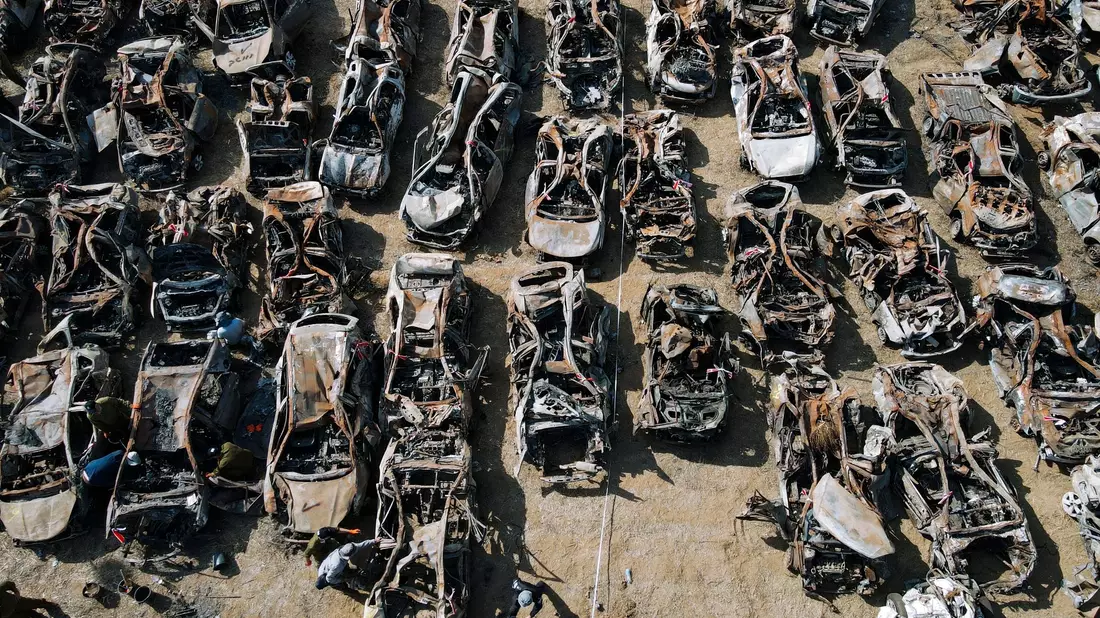 Israelische Sicherheitskräfte (unten, l) inspizieren Fahrzeuge, die bei dem Angriff der islamistischen Hamas am 7. Oktober außerhalb der Stadt Netivot im Süden Israels verbrannt wurden. - Bild: Ariel Schalit/AP/dpa