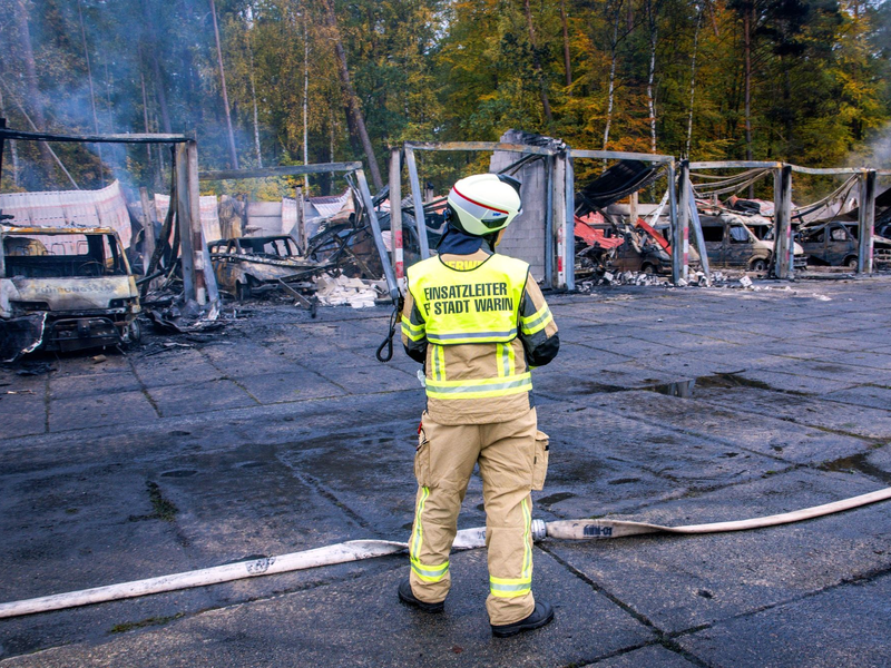 Feuerwehrleute löschen letzte Brandherde nach einem Feuer auf dem Gelände der Feuerwehr in Warin. - Foto: Jens Büttner/dpa