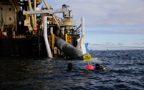 Taucher von Greenpeace protestieren  nahe des Verlegeschiffs «Castoro 10» gegen den Bau einer Pipeline für das geplante Rügener LNG-Terminal. - Foto: Lucas Wahl/Greenpeace Germany/dpa