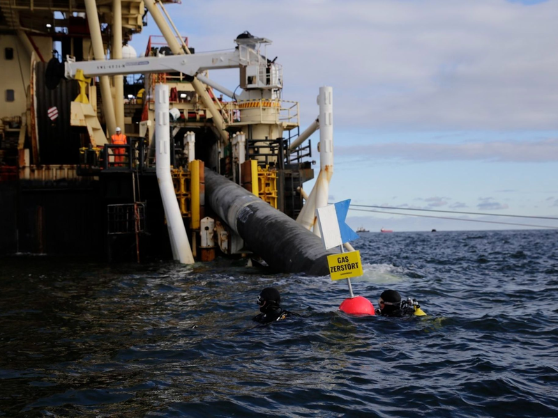 Taucher von Greenpeace protestieren nahe des Verlegeschiffs «Castoro 10» gegen den Bau einer Pipeline für das geplante Rügener LNG-Terminal. - Foto: Lucas Wahl/Greenpeace Germany/dpa