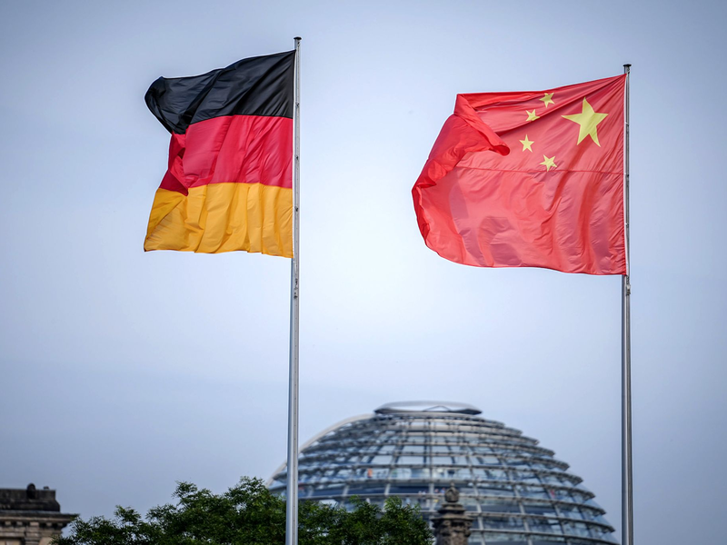 Die Flaggen von Deutschland und China wehen zum Auftakt des Deutschland-Besuchs der chinesischen Regierung vor dem Bundeskanzleramt, im Hintergrund die Kuppel des Reichstagsgebäudes. - Foto: Kay Nietfeld/dpa