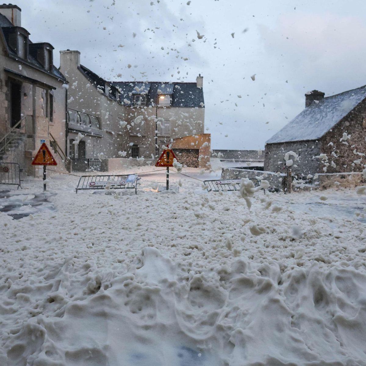 Schaum und Gischt fließen über eine Straße in Penmarc'h in Westfrankreich. - Foto: Fred Tanneau/AFP/dpa