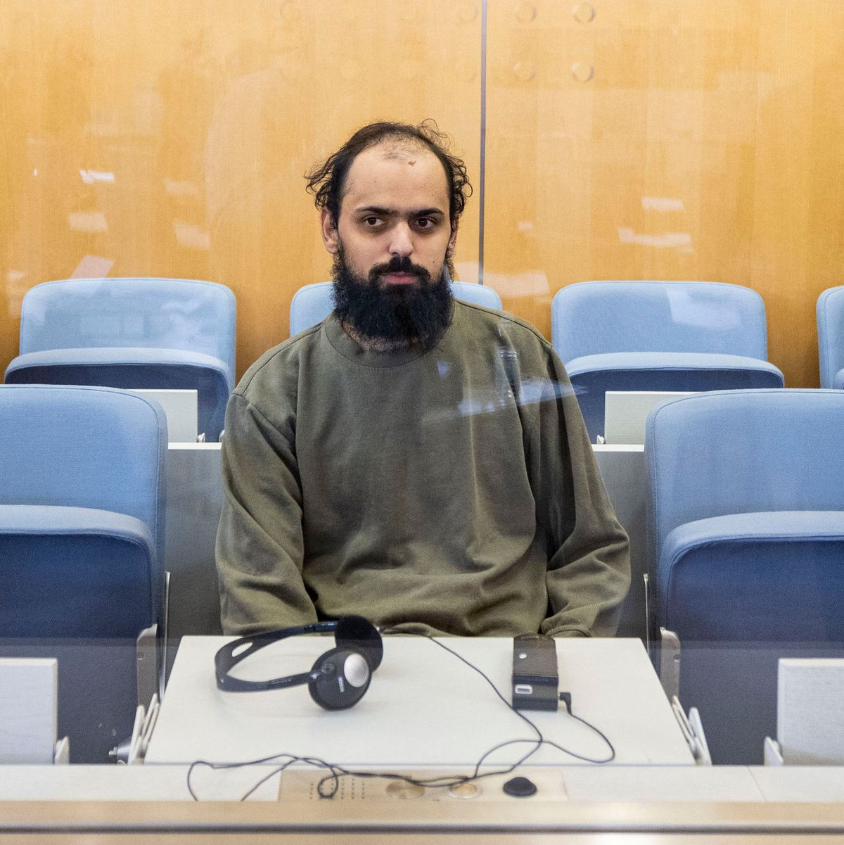 Der Angeklagte sitzt im Oberlandsgericht Düsseldorf auf der Anklagebank hinter einer Glasscheibe. - Foto: Christoph Reichwein/dpa