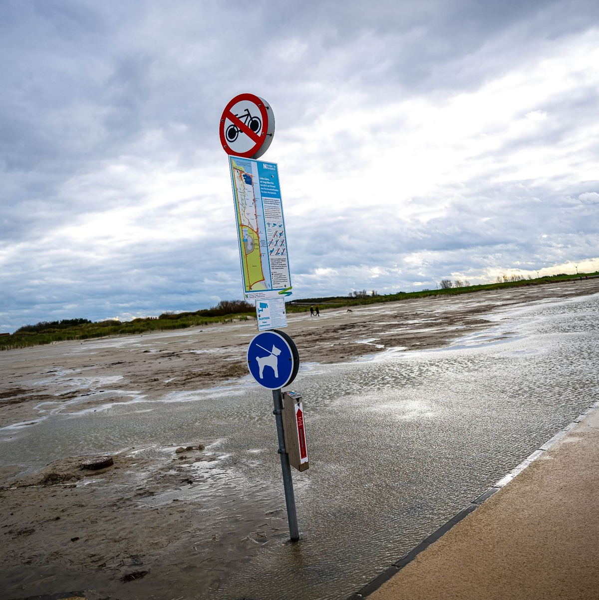 Dunkle Wolken ziehen über den Strand von Norddeich. - Foto: Sina Schuldt/dpa
