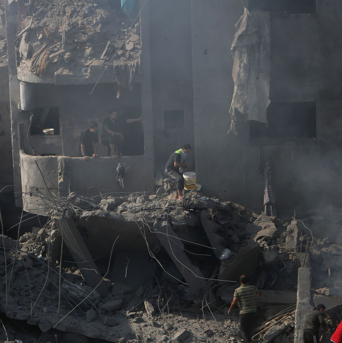 Palästinenser suchen in den Trümmern eines zerstörten Gebäudes in Bureij nach Überlebenden. - Foto: Mohammed Dahman/AP/dpa