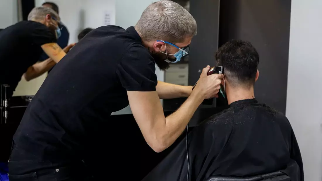 Ein Friseur schneidet die Haare eines Kunden in einem Friseursalon. - Bild: Ricardo Rubio/Europa Press/dpa