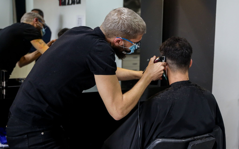 Ein Friseur schneidet die Haare eines Kunden in einem Friseursalon. - Foto: Ricardo Rubio/Europa Press/dpa