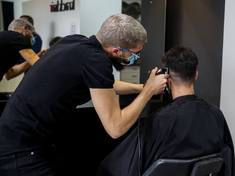 Ein Friseur schneidet die Haare eines Kunden in einem Friseursalon. - Foto: Ricardo Rubio/Europa Press/dpa