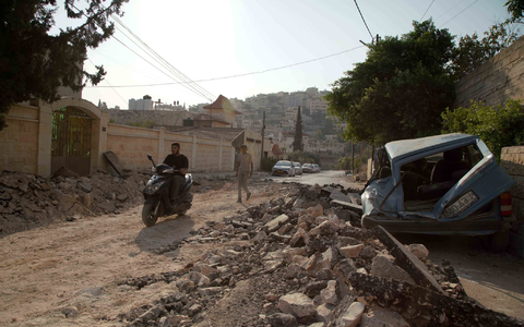 Palästinenser inspizieren die Zerstörung eines Gebiets nach schweren Zusammenstößen während einer israelischen Razzia im Flüchtlingslager Dschenin. - Foto: Stringer/dpa