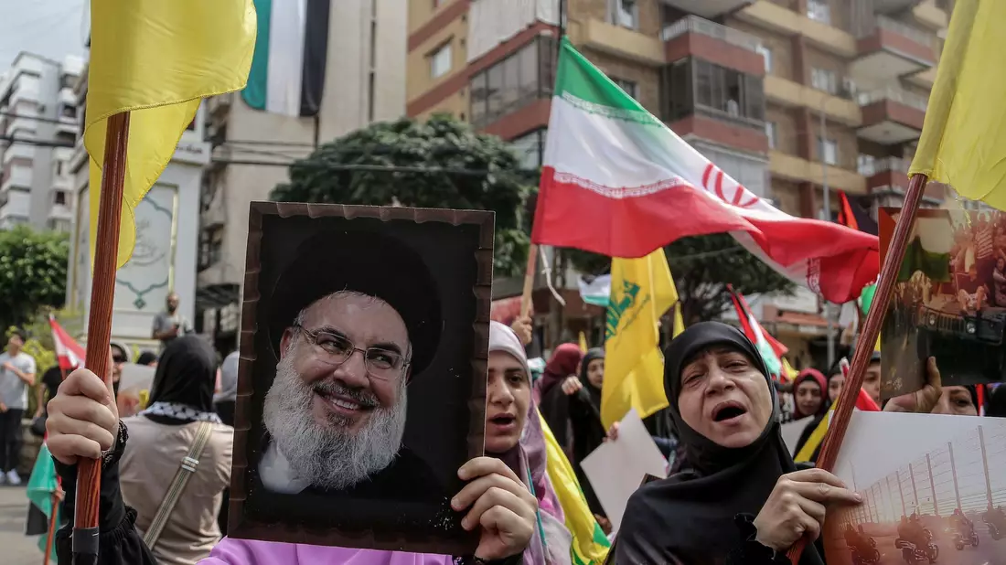 Ein Hisbollah-Anhänger hält ein Porträt von Hassan Nasrallah hoch: Der Hisbollah-Chef will sich zum ersten Mal seit Ausbruch des Gaza-Kriegs öffentlich äußern. - Bild: Bilal Hussein/AP/dpa