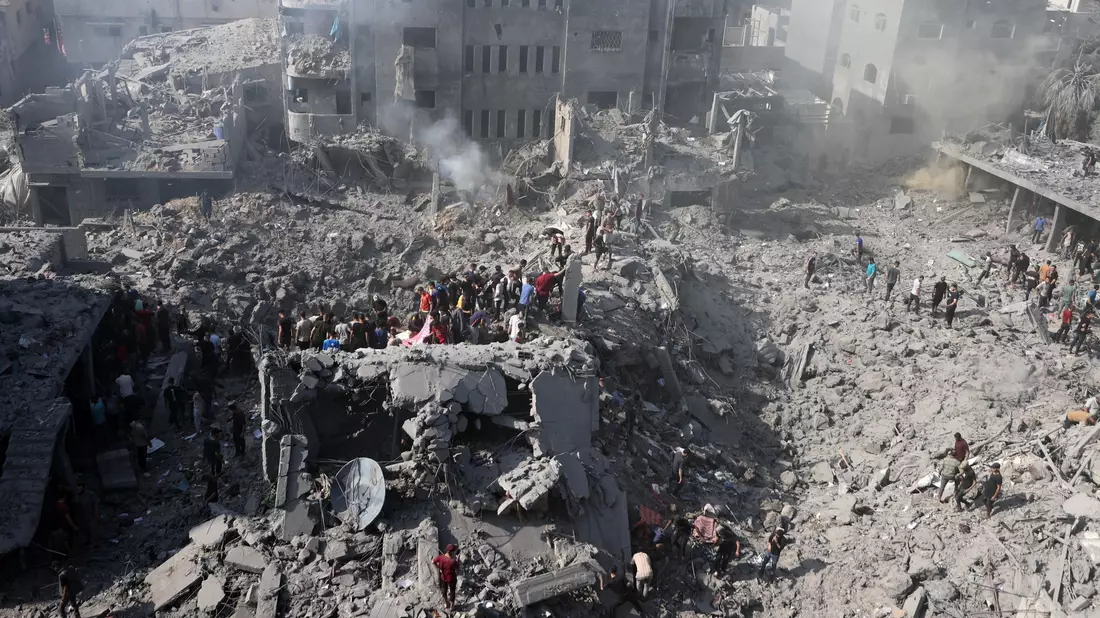 Palästinenser suchen in den Trümmern eines zerstörten Gebäudes in Bureij nach Überlebenden. - Bild: -/XinHua/dpa