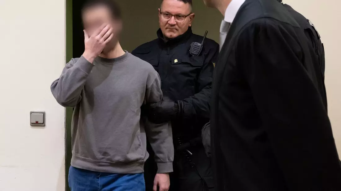 Der Angeklagte (l) wird während des Prozesses vor dem OLG München in den Verhandlungssaal geführt (Archivbild). - Bild: Sven Hoppe/dpa