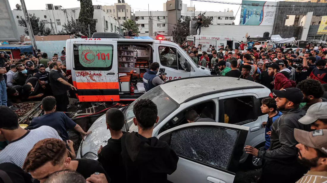 Menschen versammeln sich um einen Krankenwagen, nachdem dieser vor dem Eingang des Schifa-Krankenhaus angegriffen wurde. - Bild: -/XinHua/dpa