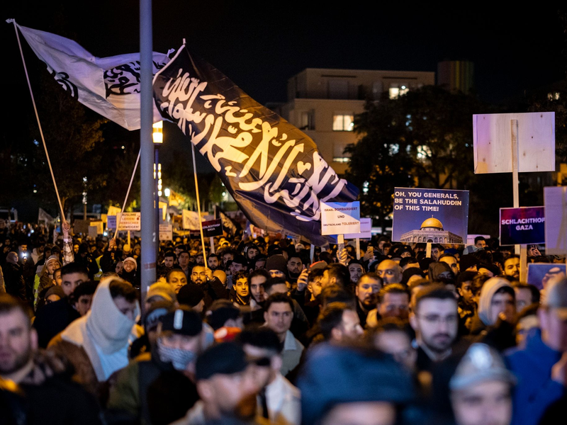 Eine Fahne mit arabischer Schrift bei der Kundgebung. Begleitet von starken Kräften der Polizei demonstrierten die Teilnehmer gegen den israelischen Militäreinsatz im Gazastreifen. - Foto: Christoph Reichwein/dpa