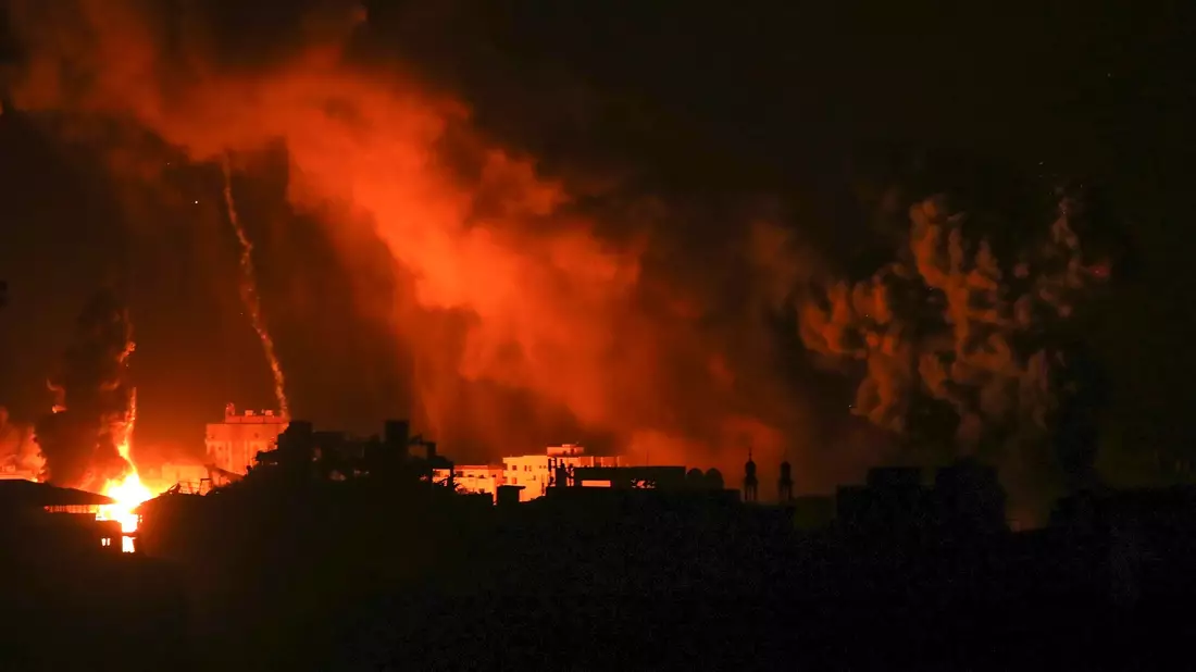 Nach israelischen Luftangriffen auf Gaza steigen Feuer und Rauch aus Gebäuden auf. - Bild: Abed Khaled/AP/dpa