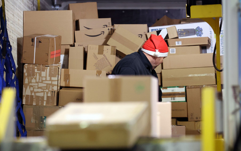 In einer Zustellbasis von DHL wird ein LKW mit Paketen entladen. - Foto: Bernd Wüstneck/dpa