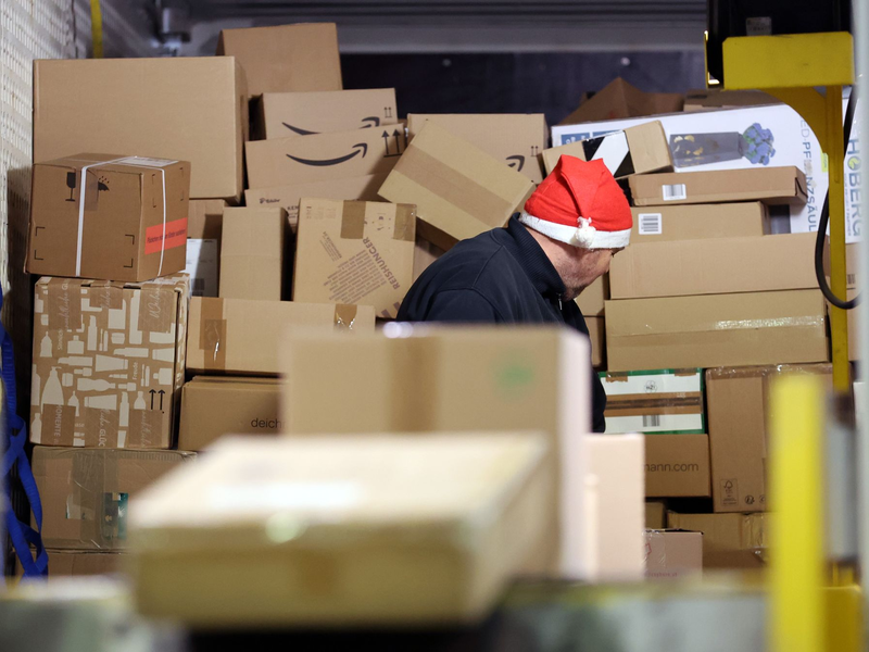 In einer Zustellbasis von DHL wird ein LKW mit Paketen entladen. - Foto: Bernd Wüstneck/dpa