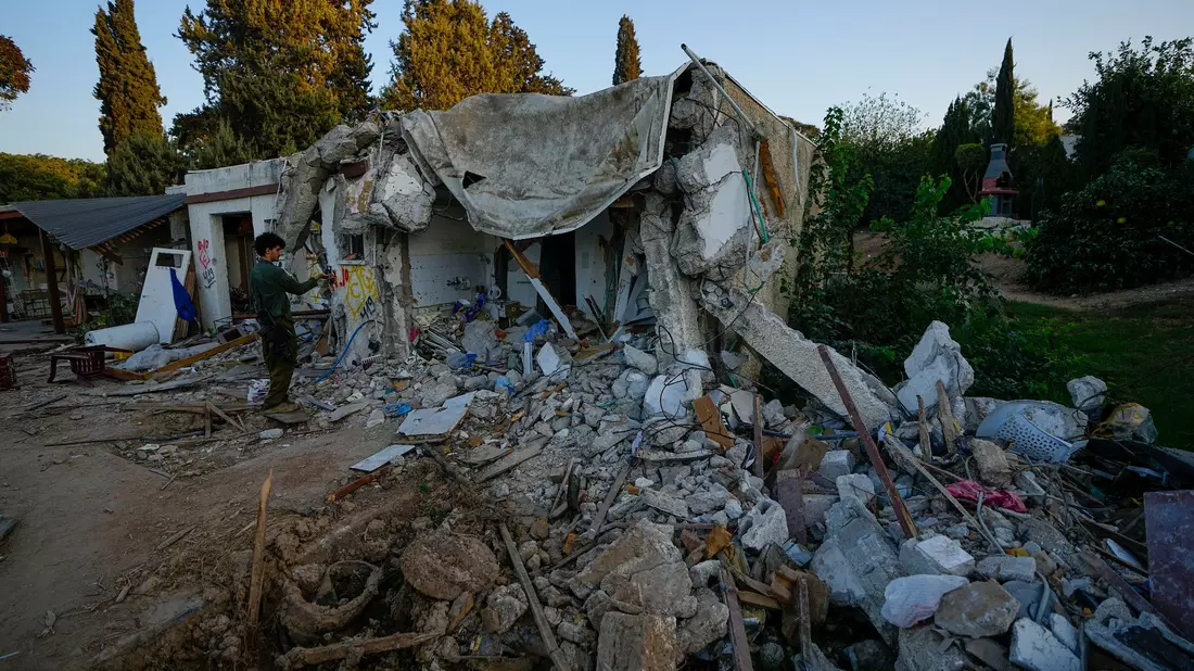 Ein israelischer Soldat inspiziert ein von Hamas-Kämpfern beschädigtes Haus im Kibbuz Kfar Azza. - Bild: Ariel Schalit/AP/dpa